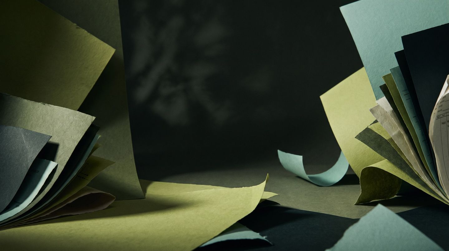 Loose sheets of ledger paper scattered in low light